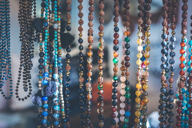 colorful mala necklaces hanging in a shop