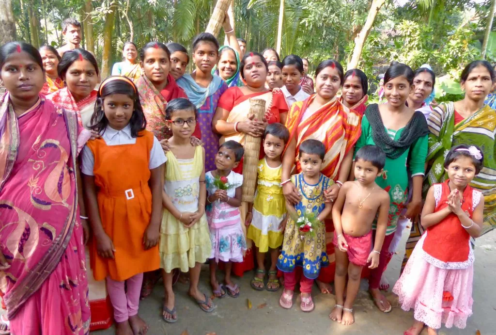 Group of Indian women and young children in colorful Indian clothing.